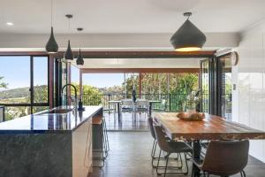 a kitchen with a table and chairs and a balcony at The Break in Lennox Head