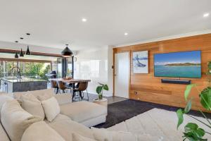 a living room with a white couch and a tv at The Break in Lennox Head