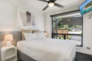 a bedroom with a white bed and a window at The Break in Lennox Head