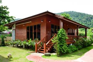 a small wooden house with a porch and a yard at PingChan Koh Phangan Beachfront Resort in Thong Nai Pan Yai