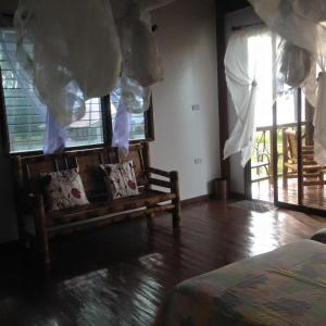 Liwayway sa Bohol Pamilacan Resort في Baclayon: غرفة بها أريكة والوسائد عليها