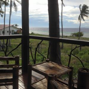 a porch with a bench and a view of the ocean at Liwayway sa Bohol Pamilacan Resort in Baclayon