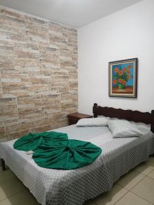 a bedroom with a bed with a green robe on it at Moinho dos ventos in São Pedro da Aldeia