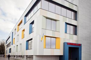 a facade of a white building with colorful windows at Hotel Versailles in Luts'k