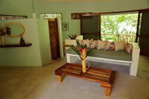 een woonkamer met een bank en een tafel met een vaas bij Cabañas Camino Mágico in San Miguel del Puerto