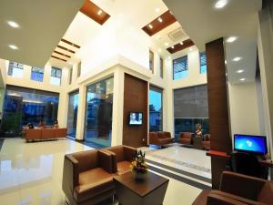 een lobby met stoelen en een tv in een gebouw bij The Color Hotel in Hat Yai