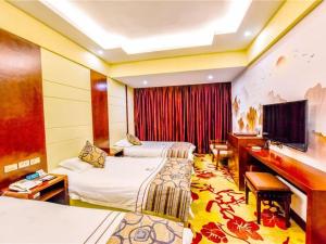 een hotelkamer met twee bedden en een televisie bij Dali Dayu Hotel in Dali