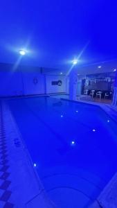 een groot zwembad in een huis met blauwe lichten bij Hotel Monte Blanco Melgar in Melgar
