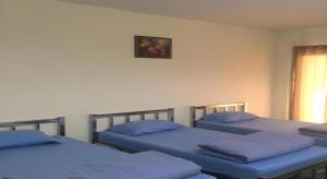 une chambre avec trois lits aux oreillers bleus dans l'établissement V.R.Mansion Hotel, à Phatthalung