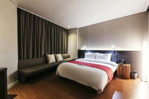 ein Schlafzimmer mit einem großen Bett und einer Couch in der Unterkunft Daesungkwan Hot Spring Hotel in Busan