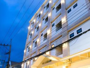 a tall white building with lights on it at Loei Residence in Ban Tha Phae