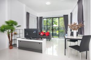 a living room with a tv and a dining room at Baan Nern Khao Resort Pattaya in Ban Huai Yai