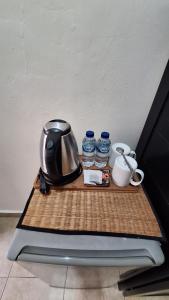 a tray with a coffee maker and two bottles of water at Jepun Bali Homestay Sanur in Sanur +20 photos