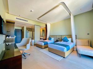 a bedroom with two beds and a desk and a chair at Matemwe Sands Hotel in Mkuyuni Pwani +63 photos