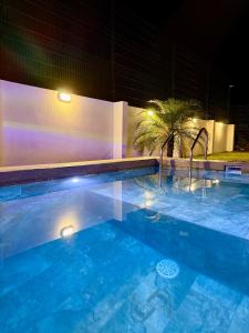 a swimming pool at night with a palm tree at Casa kai in Agujas