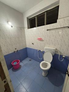 a bathroom with a toilet and a bucket at Vinayaka Deluxe Lodge in Kushālnagar +47 photos
