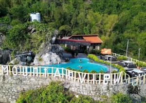 a resort with a swimming pool on a cliff at Cat Ba Mountain View Homestay in Cat Ba
