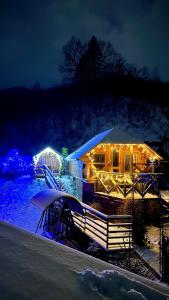 ein Haus mit Lichtern im Schnee in der Nacht in der Unterkunft VIP-Domyk in Rachiw
