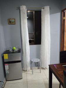 a kitchen with a refrigerator and a stool in a room at Yamis home in General Viejo +10 photos