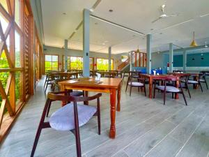 a dining room with wooden tables and chairs at Matemwe Sands Hotel in Mkuyuni Pwani