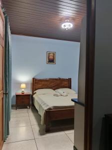 a bedroom with a bed with a wooden headboard at Yamis home in General Viejo