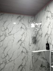 a white marble wall in a bathroom with a shelf at Yamis home in General Viejo