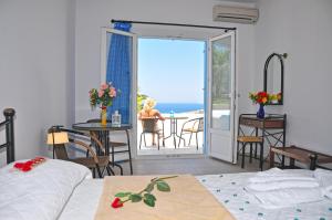 a bedroom with a view of the ocean from a balcony at Sarakiniko Rooms in Adamantas