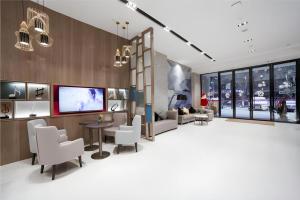 eine Lobby mit Sofa, Stühlen und Fernseher in der Unterkunft Echarm Hotel Changde Chaoyang D5 District in Changde