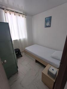 een kleine slaapkamer met een bed en een raam bij Apartamento en Ibagué Campestre in Ibagué +13 foto's