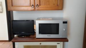 a microwave and a television sitting on a table at Apartment Via Vittoria in Bastia Umbra