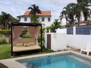 a bed in a gazebo next to a pool at Mi Casa Pool Villa Hua Hin in Hua Hin