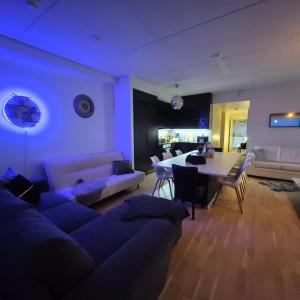 a living room with a couch and a table at TAMPERE PENTHOUSE-tasokas moderni kaupunki huoneisto huipulla -ISO JACUZZI omalla KATTOTERASSILLA - AURINKOTUOLIT ja Aurinko odottaa Sinua - huikea maisema- - 10 HLÖ - free parking in Tampere