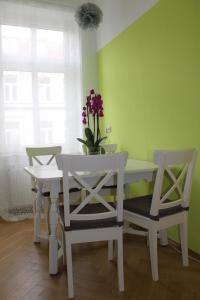 une salle à manger avec une table, des chaises et des fleurs. dans l'établissement Ferienwohnung Hecht, à Leipzig