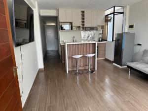 una cucina con bancone e un bar con sgabelli di Mn Depa en San Bartolo a San Bartolo