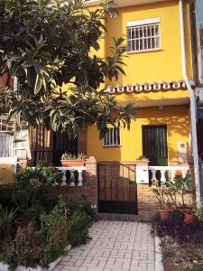 マラガにあるApartamentos MásBambúの木の前の黄色い家