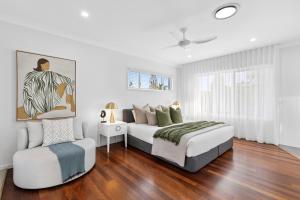 une chambre blanche avec deux lits et une chaise dans l'établissement Ocean Villa Prime Bokarina Beach Location with Pool, à Bokarina