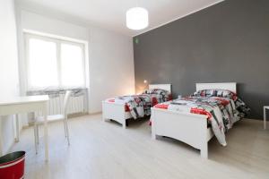 a bedroom with two beds and a desk and a window at Casa Roncalli in Foligno