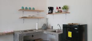 a kitchen with a counter and a sink and shelves at departamento huella in Zihuatanejo