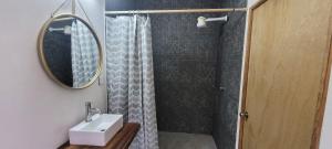 a bathroom with a sink and a shower with a mirror at departamento huella in Zihuatanejo
