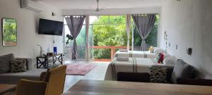 a living room with three beds and a table and chairs at departamento huella in Zihuatanejo