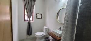 a bathroom with a toilet and a sink and a mirror at departamento huella in Zihuatanejo