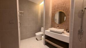ein Badezimmer mit Waschbecken, Toilette und Spiegel in der Unterkunft TC villa on beach in Ko Larn + 5 Fotos