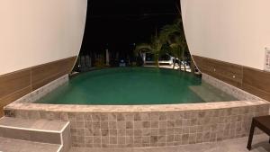 a swimming pool at night with a stone wall around it at TC villa on beach in Ko Larn