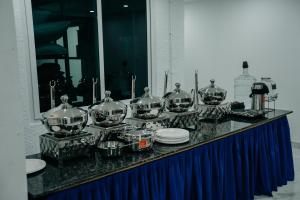 a counter with many pots and pans on it at Fenna Resort And Spa, coorg in Kushālnagar