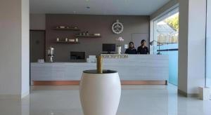 2 Personen stehen an der Rezeption in einem Zimmer in der Unterkunft Hart Hotel Premium Rapatmaja in Tjakranegara + 31 Fotos