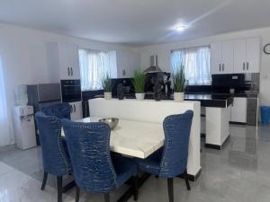 a kitchen with a table and some blue chairs at Serene 3-Bedroom House in Pridelands, Nairobi in Syokimau