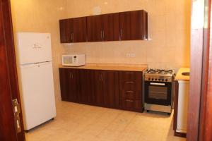 a kitchen with a white refrigerator and a stove at Makarim Najd 4 in Riyadh