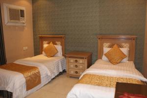 a hotel room with two beds and a night stand at Makarim Najd 4 in Riyadh