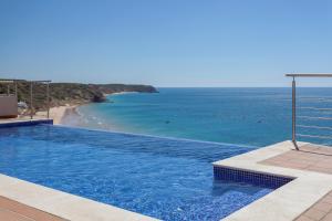a swimming pool with a view of the ocean at Villa Mar a Vista in Salema