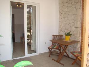 una mesa y sillas en una habitación con una pared de piedra en Villa Lipa, en Zadar